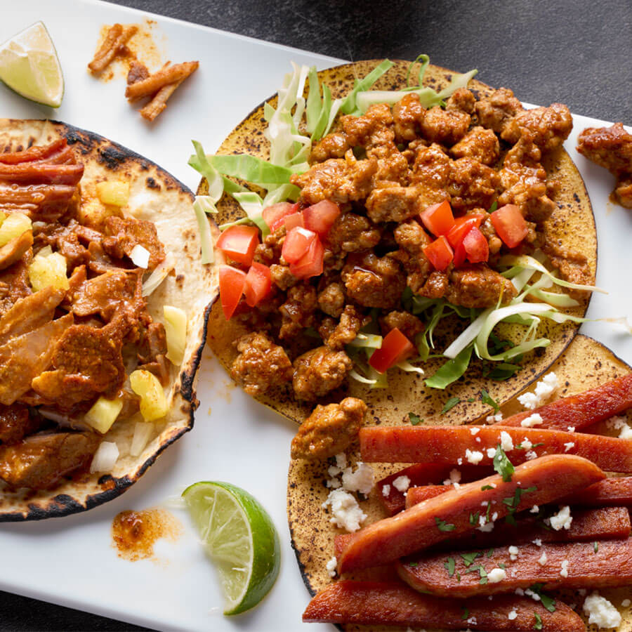 trio of tacos on white platter